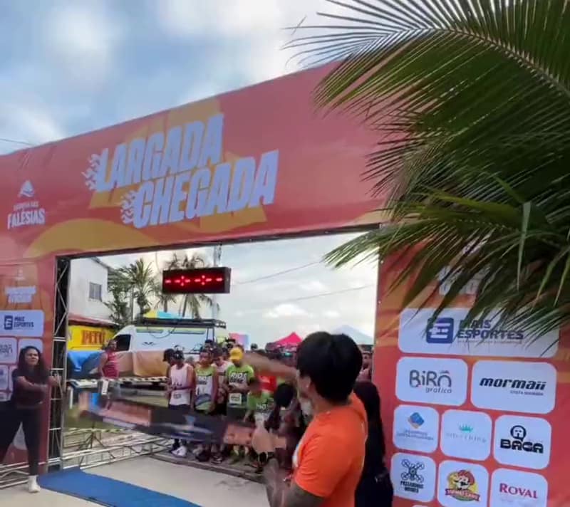 Largada da Corrida das Falésias com o pórtico laranja e os atletas saindo