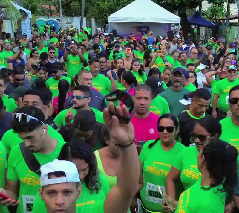 Multidão de atletas de camisa verde na concentração da largada